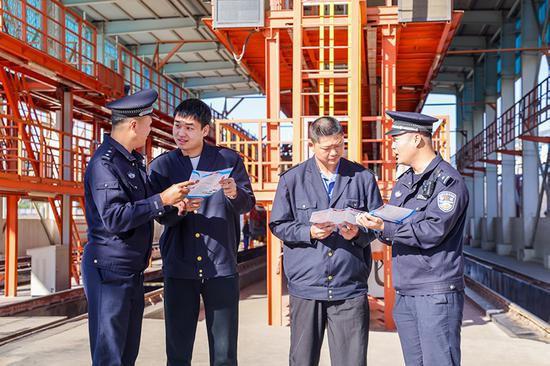 刑警支隊民警向企業(yè)職工發(fā)放宣傳資料并“一對一”講解電詐常識。謝仁古力·托呼提 攝